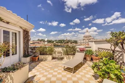 a balcony with a bench and a view of the capitol building at Attic with Terrace Overlooking St Peter's Basilica in Rome