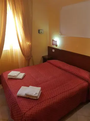a bedroom with a red bed with two towels on it at B&B Rudy in Rome