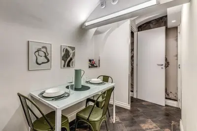 a dining room with a white table and chairs at Fori Imperiali Apartment in Rome
