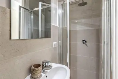 a bathroom with a sink and a shower at Fori Imperiali Apartment in Rome