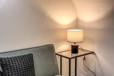 a lamp sitting on a table next to a chair at Fori Imperiali Apartment in Rome