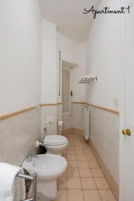 a bathroom with a white toilet and a sink at PennyLane Rome Apartment in Rome