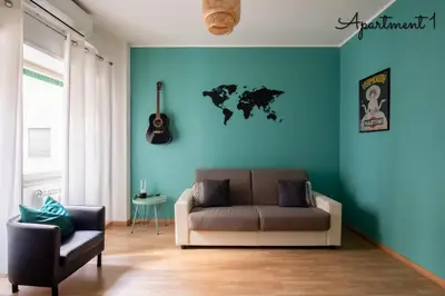 a living room with a couch and a blue wall at PennyLane Rome Apartment in Rome