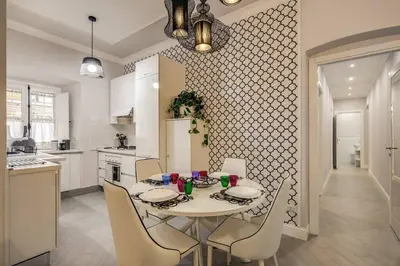 a kitchen with a table and chairs and a kitchen with a refrigerator at Flat with terrace by Vatican in Rome