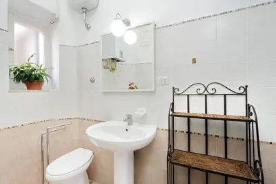a white bathroom with a sink and a toilet at Vintage 4 Bedrooms 20' Colosseum in Rome