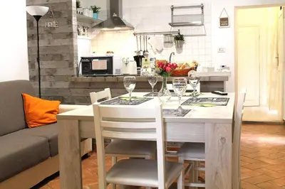 a table with chairs and wine glasses on it at 50 Passi Colosseo Apartment in Rome