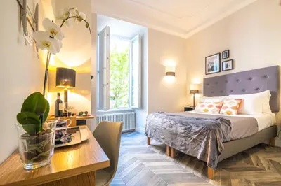 a bedroom with a bed and a table and a desk at Eccelso Hotel in Rome
