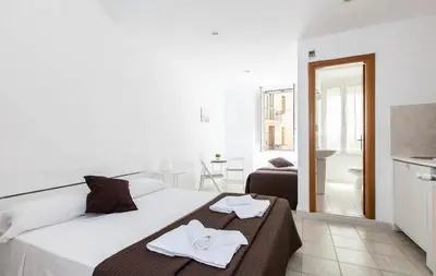 a white bedroom with a large bed with towels on it at Al Colosseo 8 in Rome