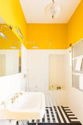 a bathroom with a white sink and yellow walls at Glamour Leonina - Monti in Rome