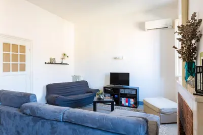 a living room with a blue couch and a tv at PIAZZA MAZZINI APARTMENT in Rome