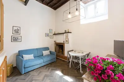 a living room with a blue couch and a table at Sara Apartment - Campo de Fiori 35 in Rome