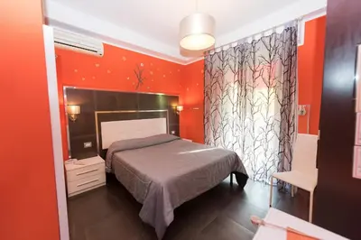 a bedroom with orange walls and a bed in a room at Roma Gianicolense in Rome