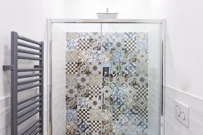 a shower in a bathroom with a tile wall at Sixty One Luxury Room in Rome