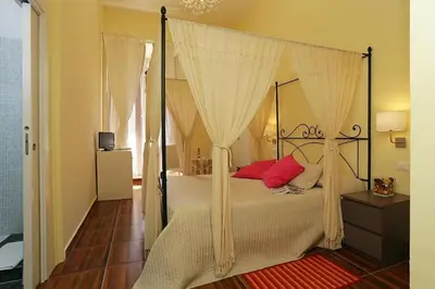 a bedroom with a canopy bed with red pillows at Locanda al Viminale in Rome