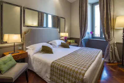 a hotel room with a large bed and a chair at Hotel Lunetta in Rome