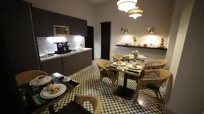 a dining room with a table and chairs and a kitchen at SuiteLifeTrevi in Rome