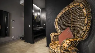 a wicker chair with a pillow in a bathroom at SuiteLifeTrevi in Rome