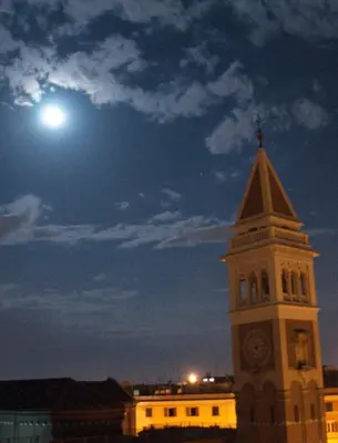 a building with a clock tower with a moon in the sky at BEACHBAR Apartment in Rome in Rome