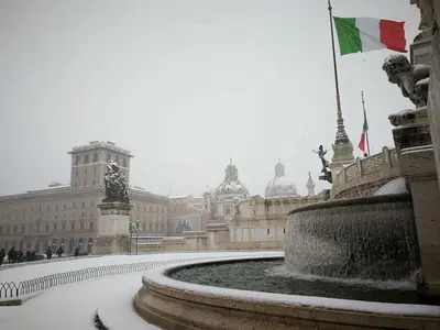 a building with a fountain in front of a building with a flag at Maison Vantaggio in Rome