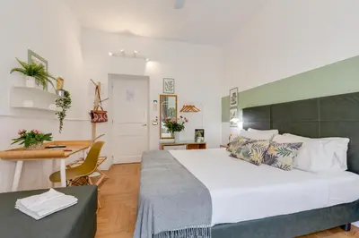 a bedroom with a large bed and a desk at Maison Vantaggio in Rome