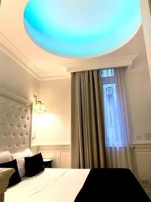 a bedroom with a bed with a blue ceiling at Tito Suite Guest House in Rome