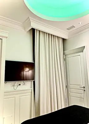 a room with a bed and a tv and a curtain at Tito Suite Guest House in Rome