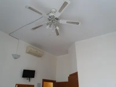 a ceiling fan in a room with white walls at Ritmo Blues Guest House in Rome