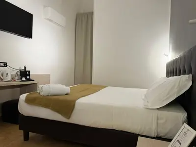 a bedroom with a large bed with a tv on the wall at Conte GuestHouse in Rome