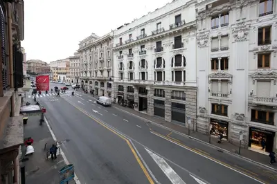 an empty city street with buildings and cars on the road at Maison Tritone in Rome
