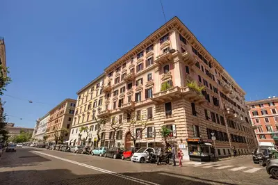 a large building on a city street with parked cars at Chester Suites in Rome