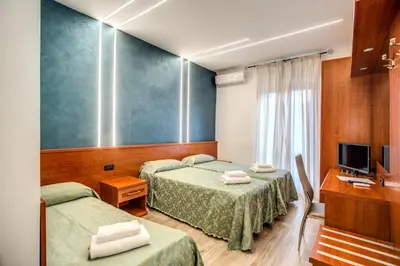 a hotel room with two beds and a television at Hotel Millerose in Rome