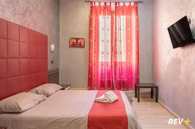 a bedroom with a bed with a red headboard and a window at New Inn in Rome