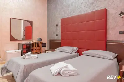 a bedroom with two beds and a red headboard at New Inn in Rome
