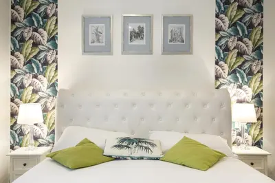 a bedroom with a white bed with green pillows at Aeterna Rooms Collection GuestHouse in Rome