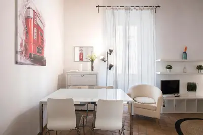 a white dining room with a white table and chairs at Imperial Loft in Rome