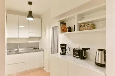a kitchen with white cabinets and a sink at iFlat Via Veneto Design Studio in Rome