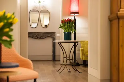 a dining room with a table with flowers and mirrors at Casa Fabbrini Fancy Suites in Rome