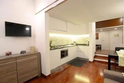 a kitchen with white cabinets and a dining room at Home Alex in Rome