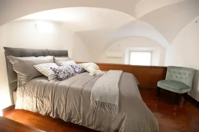a bedroom with a bed with a chair and a window at Home Alex in Rome