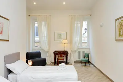 a hotel room with two beds and a chair at Sistina 2 in Rome
