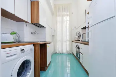 a kitchen with a washing machine and a blue floor at Sistina 2 in Rome