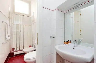 a white bathroom with a sink and a toilet at Sistina 2 in Rome