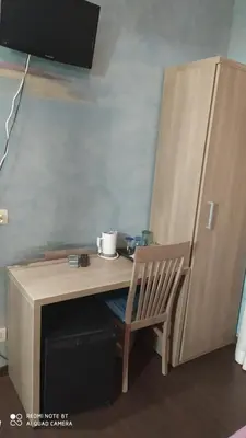 a wooden desk with a chair next to a refrigerator at Art And Relax Suites in Rome