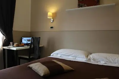 a bedroom with a bed and a desk with a computer at Hotel Indipendenza in Rome