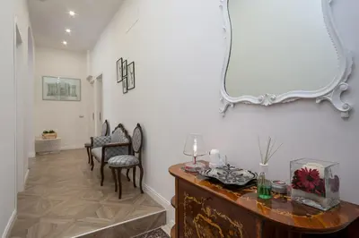 a living room with a table and chairs and a mirror at La Terrazza a San Pietro in Rome