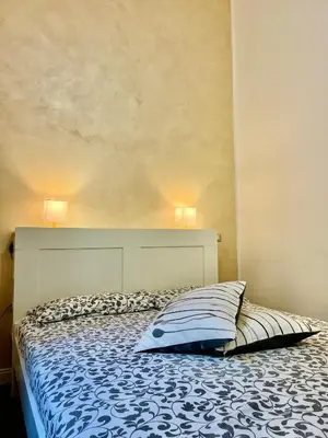 a bed in a bedroom with two lamps on the wall at La Terrazza a San Pietro in Rome