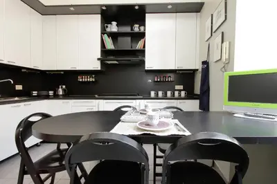 a kitchen with a table with chairs and a computer at Vatican House Via Terenzio in Rome