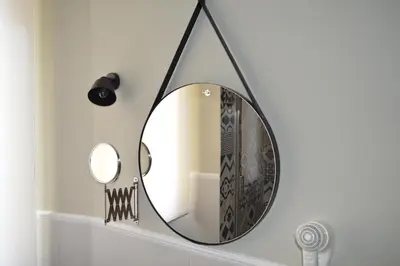 a bathroom with a round mirror hanging on a wall at romantica guest house in Rome