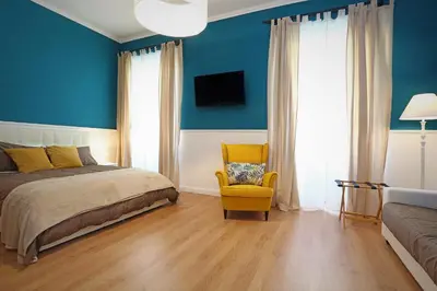 a blue bedroom with a bed and a yellow chair at romantica guest house in Rome