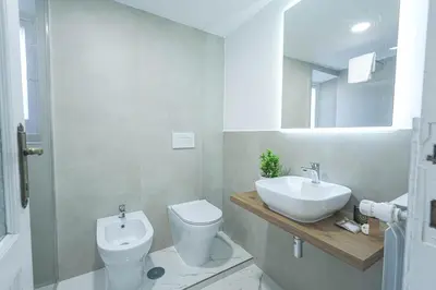 a white bathroom with a sink and a toilet at SuityRHome RioneMonti37 in Rome
